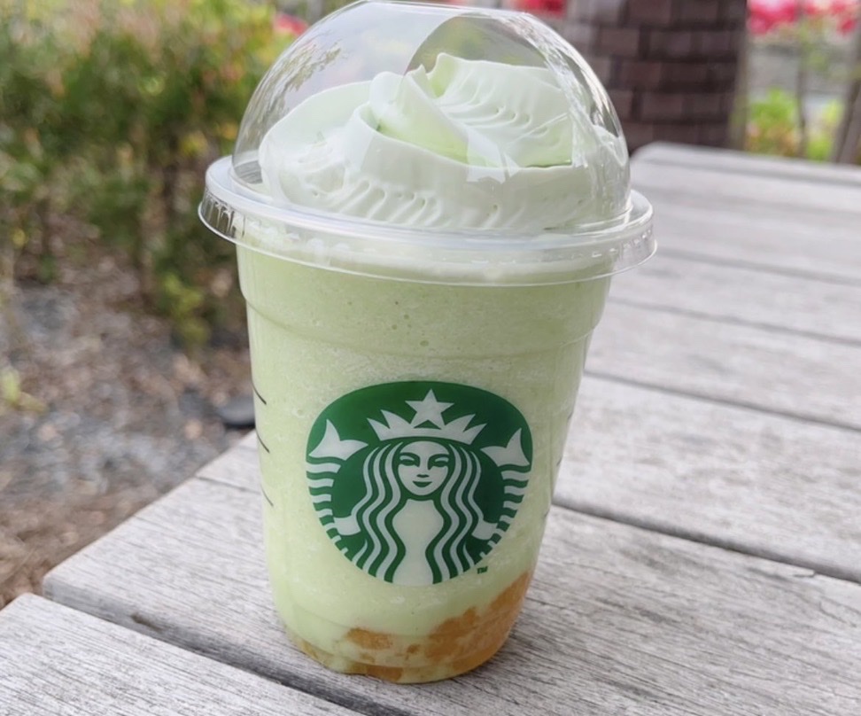 屋外のテーブルに置かれたミント色のフラペチーノ